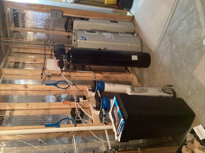 Responded to service call for recently installed whole home water softening system. Performed diagnostic testing on water softener unit to verify proper operation and softness levels. Confirmed system is functioning within manufacturer specifications and producing appropriately softened water throughout the home. Addressed customer concerns regarding the slippery feel characteristic of softened water. Discussed options for accommodating different water preferences within the household. Provided recommendation to install separate hard water plumbing line to basement bathroom with dedicated water heater to bypass the softening system for that specific area. Explained the installation process would involve running new copper or PEX supply lines from the main water line before the softener unit, routing through basement framing to bathroom location, and connecting to a separate water heater. Reviewed salt type options and their effects on water feel, though current system performance meets