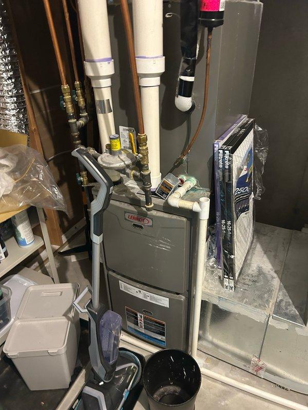 Completed comprehensive AC tune-up and maintenance inspection on 8-year-old Lennox system with no known issues. Performed thorough evaluation including thermostat calibration, filter assessment, blower assembly inspection, outdoor condenser coil examination, electrical component testing, contactor and capacitor verification, condensate drain check, refrigerant charge analysis, and temperature split measurements. All system parameters and readings measured within manufacturer specifications with no mechanical defects, safety concerns, or performance issues identified. Verified proper operation of outdoor condensing unit with cylindrical design, refrigerant line connections, and electrical disconnect. Inspected indoor furnace installation including PVC venting, gas line connections with pressure regulator, and copper refrigerant lines. System operating efficiently and reliably. Advised continued regular filter replacement, maintaining clean indoor and outdoor coils, and scheduling routin