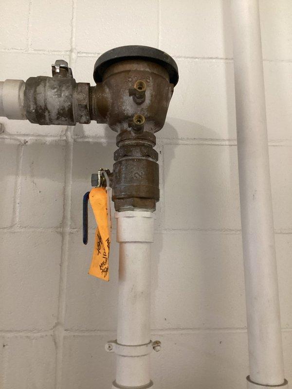 Responded to service call for malfunctioning pressure vacuum breaker (PVB) backflow preventer on irrigation system. Upon inspection, found the unit actively leaking with water continuously spraying back and unable to shut off properly. The metal valve assembly showed heavy rust and corrosion, indicating significant age-related deterioration. Assessed the Wilkins Zurn 720A backflow device and determined it required either complete rebuild or replacement. Documented the existing condition with photographs showing the corroded metal components and mounting configuration on exterior wall. Researched appropriate repair kit options (RK2-720A) for potential rebuild scenario. Provided detailed estimate to corporate office for approval, presenting both rebuild and full replacement options for the failing backflow prevention assembly.