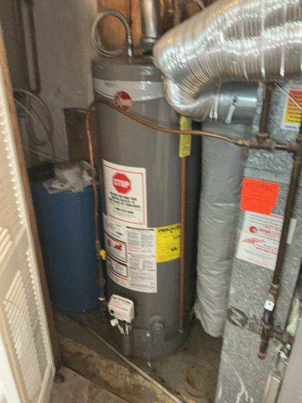 Responded to emergency call for flooding on lower level with water present in utility room. Upon arrival, confirmed water infiltration originating from toilet overflow and dishwasher operation, indicating main sewer line obstruction. Performed initial assessment and determined primary drain line was completely blocked, preventing proper wastewater discharge from plumbing fixtures. Documented existing conditions in utility room area including water heater installation and mechanical systems. Scheduled comprehensive drain cleaning service to clear main line blockage and restore proper drainage function to all affected fixtures.
