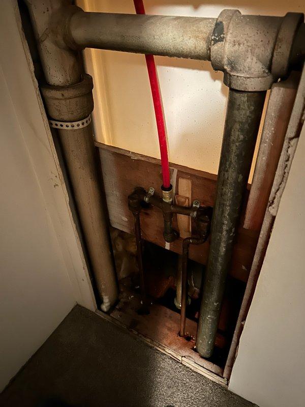 Responded to emergency plumbing call for active pipe leak behind shower wall causing water damage to basement below. Main water supply was shut off upon arrival to prevent further damage. Diagnosed hot water control issue at bathtub faucet where hot water valve failed to shut off completely. Accessed plumbing behind shower wall and replaced defective valve seat and washer assembly. Installed new ball valves on both hot and cold water supply lines feeding the shower to provide improved shutoff capability and facilitate future maintenance access. Tested all fixtures for proper operation and verified leak was resolved with no active water flow detected behind wall or into basement area.