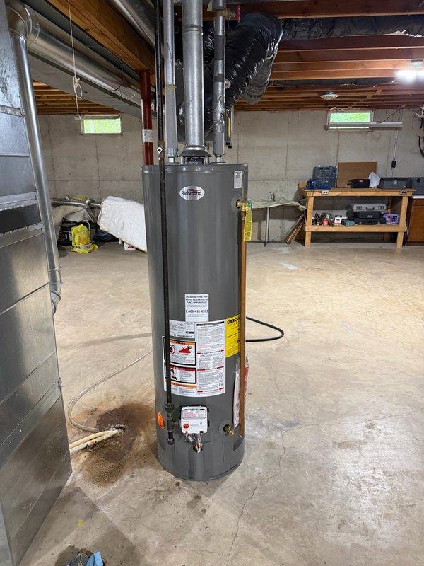 Completed installation of customer-supplied 40-gallon Richmond natural gas water heater in basement utility room. Removed existing unit, installed new water heater with proper venting connections to existing ductwork, connected gas and water supply lines, and tested system for proper operation and safety compliance.
