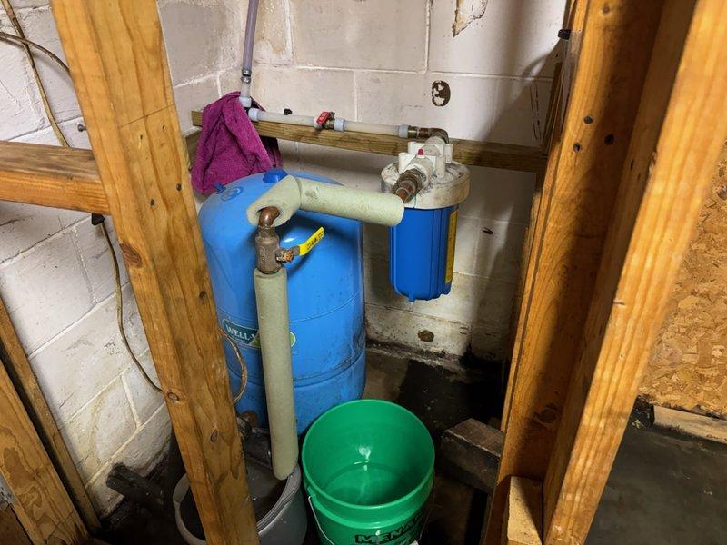 Responded to basement water leak caused by pinhole leak in copper pipe upstream of sediment filter and pressure tank system. Replaced defective ball valve and repaired compromised copper piping to restore proper water flow and eliminate active leak. System tested and verified operational with no additional leaks detected.