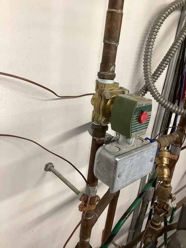 Responded to emergency service call for irrigation water interruption issue. Upon inspection, diagnosed a failing ASCO Red-Hat II two-way solenoid valve assembly that was preventing proper water flow to the irrigation system. Removed the defective solenoid valve unit, including the green and cream-colored control mechanism with junction box and associated electrical connections. Installed straight pipe section to bypass the failed valve assembly and restore direct water flow to the irrigation system. Verified proper water flow and system operation upon completion.