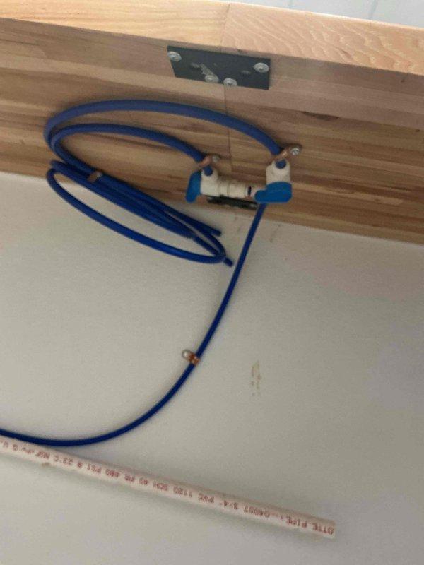 Supplied and installed all necessary piping and fittings to connect commercial espresso machine to building water supply and drain systems in compliance with Minnesota plumbing code. Installation included white PVC drain lines configured in proper U-trap formation and blue flexible water supply line with brass fittings secured to structural joists. All connections tested and verified operational with 1-year parts and labor warranty included.