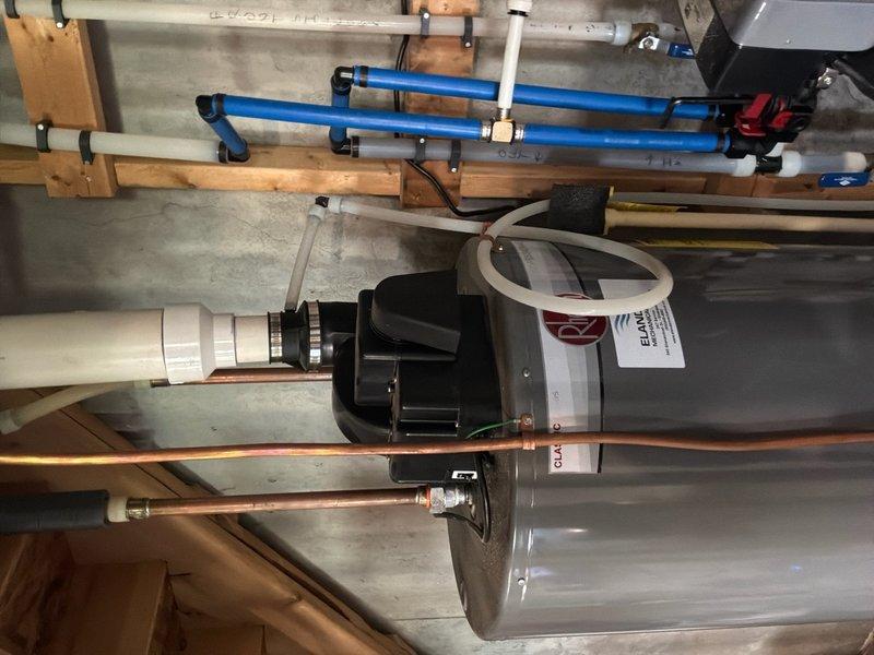 Responded to service call for 50-gallon natural gas power vent water heater manufactured in 2017 experiencing active leak from bottom of unit. Upon inspection, confirmed water leakage originating from base of tank due to cracked internal liner, indicating tank failure. Documented existing installation including power vent motor assembly, PVC venting system, and copper supply lines. Photographed mechanical components and piping configuration for replacement estimate purposes. Provided comprehensive estimate for complete water heater replacement due to non-repairable tank failure.