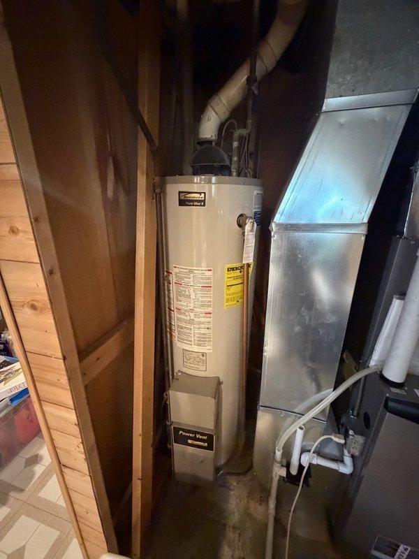 Completed comprehensive plumbing inspection of residential mechanical room, examining water heater installation, piping connections, and associated plumbing systems. Documented existing Kenmore Power Miser 9 water heater with power vent configuration, pressure relief components, and PVC/steel pipe routing for service records.