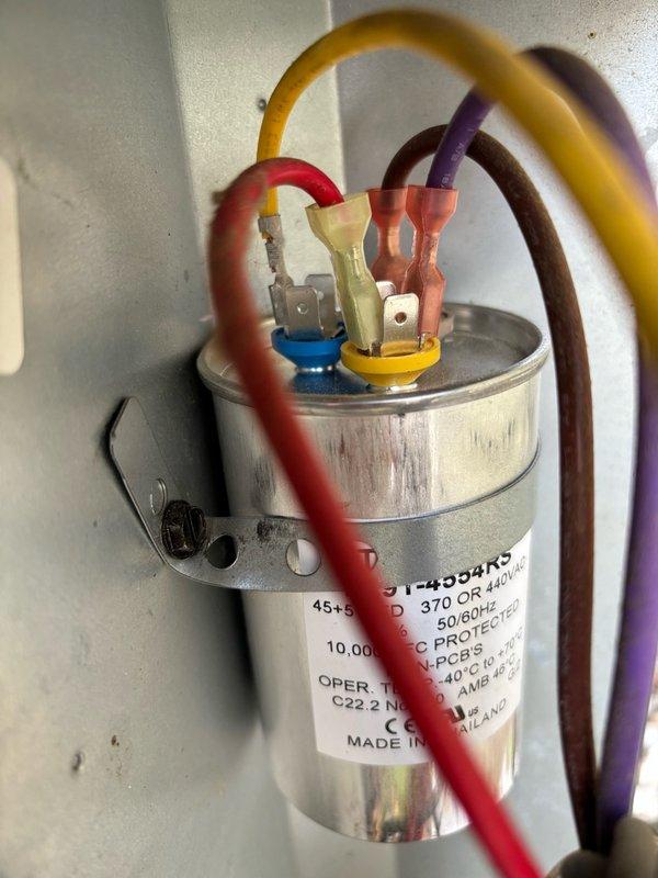 Performed comprehensive air conditioning maintenance on a 2018 Goodman condenser unit. Addressed cabinet integrity issues by installing replacement screws to secure loose panels and stabilize the frame. Tested the dual run capacitor, confirming proper operation at 44.8/5.0 µF within manufacturer specifications of 45/5 µF. Verified refrigerant charge with an 18°F temperature split indicating adequate system performance. Cleaned condenser coils and inspected all major components. System is currently operating within normal parameters, though cabinet construction quality warrants monitoring during future service visits.