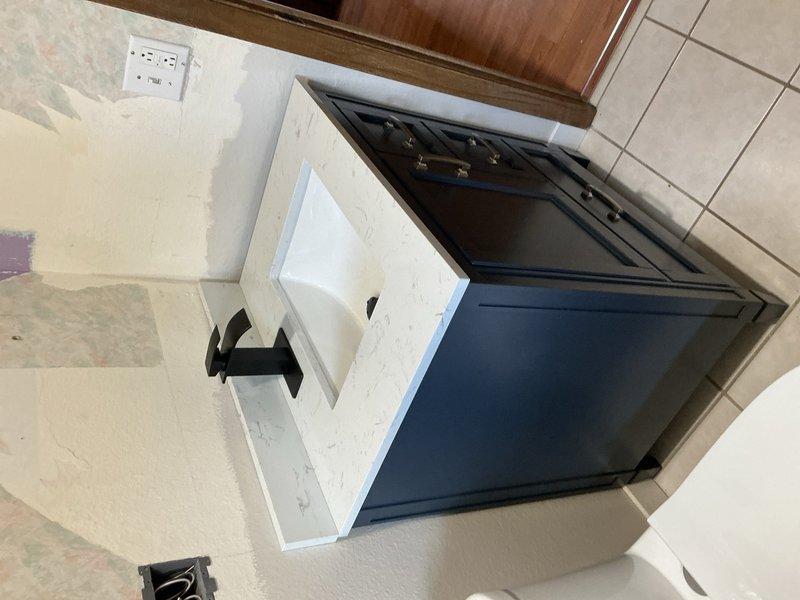 Completed installation of customer-supplied toilet with new angle stop valve in bathroom. Installed two customer-supplied sinks including vanity unit with associated drain assemblies and supply connections. Installed customer-supplied kitchen faucet and ran ice maker supply line to refrigerator location. Installed ball valve for outdoor faucet above water heater location, with valve sized up to 1 inch. Removed and hauled away existing toilet, sinks, and vanity as requested. All fixtures tested for proper operation and checked for leaks upon completion.