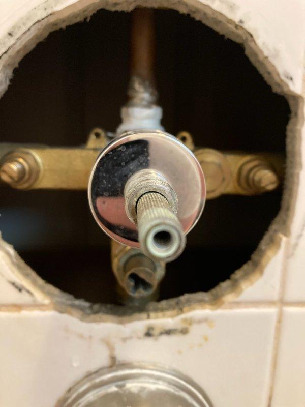 Responded to service call for malfunctioning shower valve that would not shut off completely. Accessed valve assembly through existing wall opening in tiled shower enclosure. Inspected Delta rough-in valve body and cartridge assembly, which showed signs of corrosion and mineral buildup causing failure to seal properly. Assessed condition of existing chrome escutcheon plate, spout, and trim fixtures. Provided detailed estimate for complete shower valve replacement including new Delta pressure-balance valve cartridge, trim kit, and spout to restore proper operation and shutoff capability.