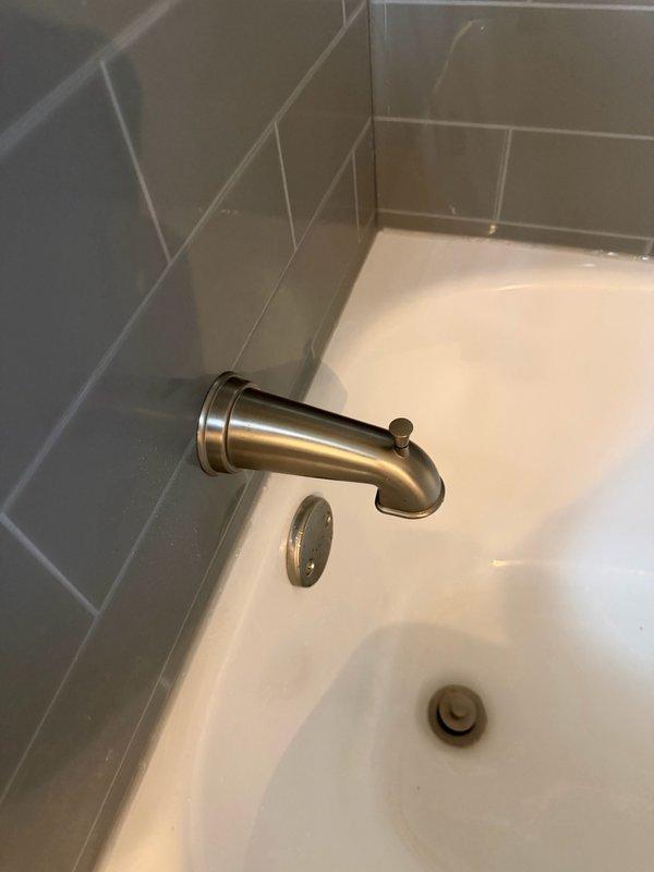 Responded to service call for multiple plumbing drainage issues affecting two bathrooms. Cleared hair obstruction from upstairs bathtub/shower drain, restoring proper drainage function. Removed and extracted stuck drain stopper assembly from downstairs bathtub to allow water flow. Inspected downstairs toilet and confirmed normal flushing operation. Identified malfunctioning shower diverter requiring replacement and provided estimate for repair. Documented existing conditions with photographs showing tiled bathtub surrounds, fixtures, and drain assemblies.