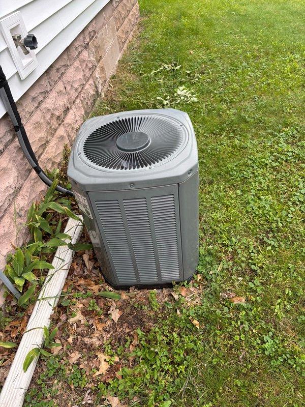 Completed comprehensive preventive maintenance on a 2005 Trane R-22 air conditioning system as part of a recurring maintenance agreement. System is currently operational with an 18°F temperature split across the evaporator coil, though refrigerant charge appears slightly low. Inspected outdoor condenser unit, which showed normal wear consistent with age, and evaluated dual-run capacitor showing corrosion and weathering on terminals. No immediate operational failures detected at this time. Discussed system replacement options with homeowner, highlighting benefits of upgrading from aging R-22 equipment to newer, more energy-efficient technology that would provide quieter operation and improved long-term reliability.