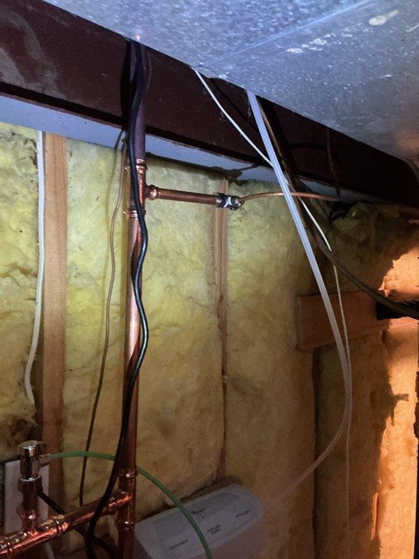 Replaced failed water supply shutoff valves and deteriorated copper piping section serving the ice maker connection. Installed new shutoff valves and copper supply line to ensure proper water delivery and emergency shutoff capability, preventing potential water damage from compromised components. Work completed in unfinished basement utility area with all connections tested and verified operational.