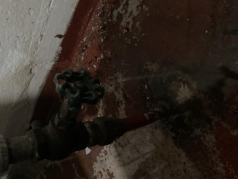 Responded to water leak in basement caused by failed main shut-off valve on city side of meter. Upon inspection, found stem packing nut seized and leaking, with extensive corrosion present on existing valve assembly. Documented conditions with photographs showing deteriorated valve components and surrounding piping. Provided estimate for replacement of first valve with 3/4" threaded ball valve to accommodate existing 3/4" copper supply line entering approximately 6 inches into structure. Customer requested time to consult before authorizing repair work.