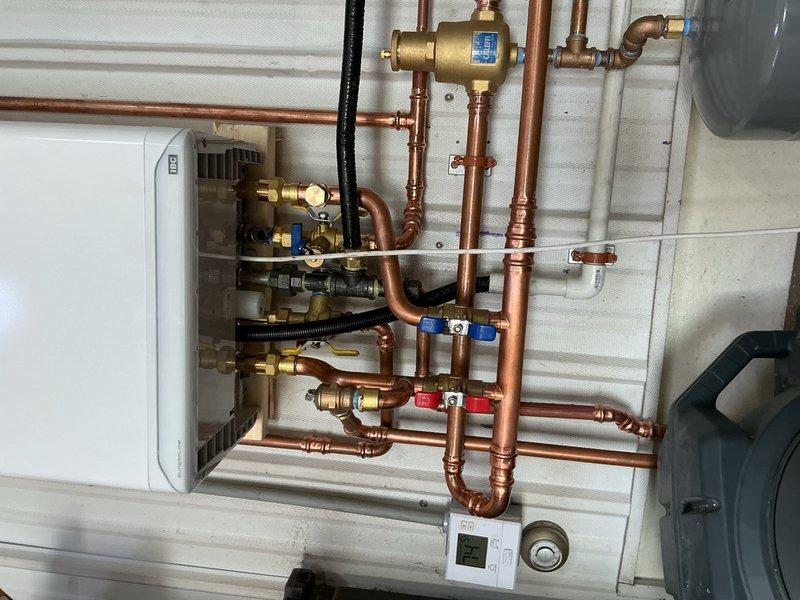 Removed and replaced failed leaking combination boiler with new IBC tankless combi unit in commercial facility. Completed installation of new boiler system with copper piping, brass valves, and necessary fittings. Successfully commissioned domestic hot water side of system and verified operation. Heating zone wiring remains incomplete and requires return visit to finalize electrical connections for space heating functionality.