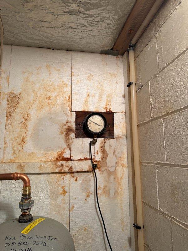 Responded to a water leak emergency in the basement where a pinhole leak was identified in the copper piping located before the pressure tank on the well system. Water supply to the home had been shut off prior to arrival. Upon inspection, confirmed the pinhole leak in the copper pipe section between the well pipe and pressure tank, which had caused significant rust staining on the surrounding walls and surfaces. Removed the compromised section of copper piping and installed new copper pipe with proper fittings. Restored water pressure by turning the pressure tank back on, performed a thorough leak check of the repair area, and tested water flow at the kitchen faucet to verify proper system operation and pressure restoration.