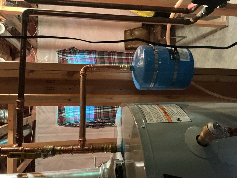 Responded to leaking temperature and pressure relief valve on a three-year-old water heater that was previously installed without an expansion tank. Upon arrival, found homeowner had rigged a temporary hose to direct water flow from the leaking T&P valve to the floor drain. Diagnosed the issue as thermal expansion causing excessive pressure in the closed plumbing system due to the absence of an expansion tank during original installation.

Installed a new expansion tank to accommodate thermal expansion and prevent future pressure buildup in the system. Replaced the failed temperature and pressure relief valve with a new unit. Properly connected the expansion tank to the cold water supply line using appropriate copper piping and fittings. Tested the system for proper operation and verified that all connections were secure with no leaks present.

Additionally, delivered and installed a UV bulb for the furnace as part of the service call. All work completed to code specifications, and the