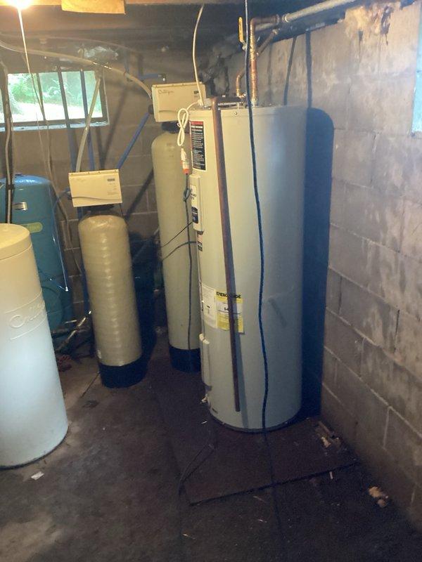 Responded to no hot water call with reported electrical issues including tripped breaker and sparking. Upon inspection, diagnosed failed heating elements and thermostats in existing 50-gallon electric water heater. Provided estimate for complete water heater replacement due to electrical failure and safety concerns. Documented existing installation showing water heater located in basement utility area with water treatment systems, along with electrical panel configuration. Recommended replacement over repair given the severity of electrical issues and potential safety hazards.
