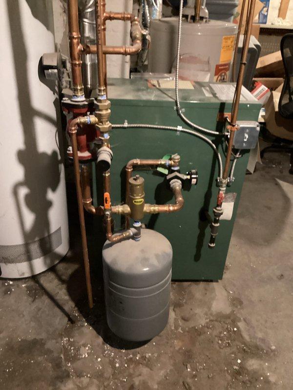 Responded to service call for inconsistent hot water production from an A.O. Smith ProMax tanked water heater over 20 years old. Upon inspection, confirmed unit was intermittently delivering hot and cold water, indicating heating element or thermostat failure consistent with age-related deterioration. Accessed unit through rear basement entrance and documented existing installation including copper supply piping, proximity to green boiler system with expansion tank, and overall mechanical room configuration. Recommended complete water heater replacement due to advanced age beyond typical service life and unreliable performance affecting household hot water availability.