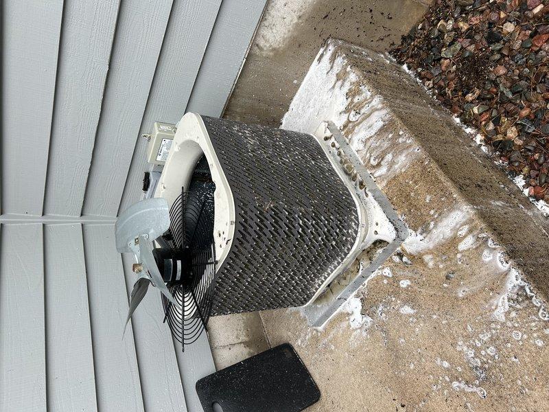 Responded to no cooling complaint on 16-year-old residential air conditioning system. Upon arrival, found outdoor condenser unit running but not providing adequate cooling to home. Diagnostic inspection revealed burned common wire connection on capacitor and heavily corroded capacitor requiring immediate replacement. Unit exterior was excessively dirty with significant debris accumulation affecting airflow and heat transfer efficiency. Performed thorough cleaning and washing of condenser coil and cabinet. Installed new capacitor and verified proper electrical connections. Conducted refrigerant pressure check and identified system was low on R-22 refrigerant. Restored system to operational status with improved cooling performance.