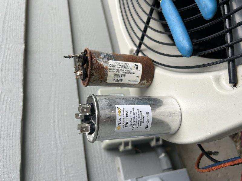 Responded to no cooling complaint on 16-year-old residential air conditioning system. Upon arrival, found outdoor condenser unit running but not providing adequate cooling to home. Diagnostic inspection revealed burned common wire connection on capacitor and heavily corroded capacitor requiring immediate replacement. Unit exterior was excessively dirty with significant debris accumulation affecting airflow and heat transfer efficiency. Performed thorough cleaning and washing of condenser coil and cabinet. Installed new capacitor and verified proper electrical connections. Conducted refrigerant pressure check and identified system was low on R-22 refrigerant. Restored system to operational status with improved cooling performance.