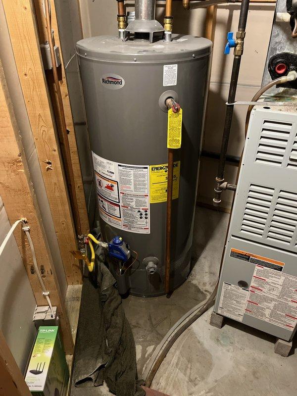 Responded to service call for 40-gallon natural gas tanked water heater experiencing active leak from bottom of unit. Upon arrival, confirmed 9-year-old Richmond brand water heater had ruptured tank with water actively leaking from base. Determined unit was beyond repair and required complete replacement. Removed and disposed of failed water heater, then installed new Bradford White 40-gallon natural gas water heater with proper venting and code-compliant connections. Connected copper supply lines with brass fittings and shutoff valves, installed gas line with appropriate yellow-tagged safety valve, and verified all plumbing connections for leaks. Tested unit operation, confirmed proper ignition and heating function, and ensured all safety features were operational before completing installation.