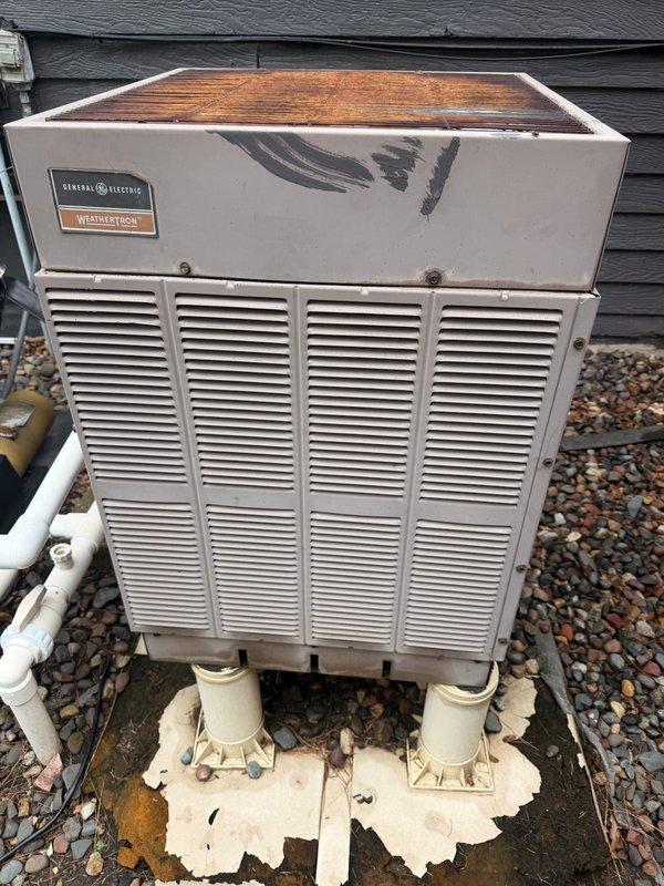 Responded to no-cooling complaint on residential split system with approximately 40-year-old General Electric Weathertron outdoor unit. Upon inspection, found severely restricted airflow due to plugged A-coil, failed blower motor with oil leakage contaminating internal components, and cracked heat exchanger presenting safety concern. Discussed findings and system condition with homeowner, including age-related equipment failure and safety issues. Coordinated comfort advisor consultation for system replacement recommendations given extensive component failures and advanced age of equipment beyond economical repair.