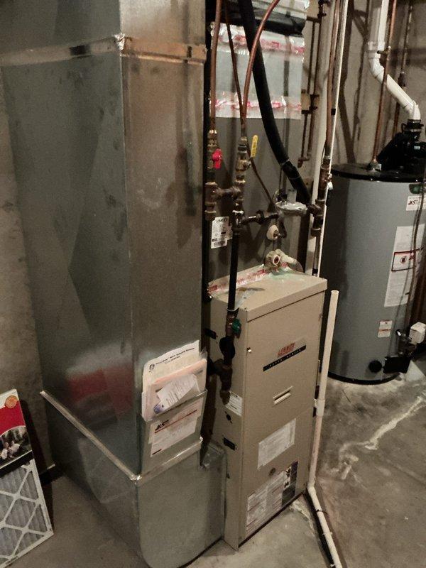 Performed comprehensive plumbing inspection at vacant residential property in preparation for sale. Identified and diagnosed multiple issues including leaking faucet handles at base on two upper-level bathroom fixtures and one additional bathroom faucet, all requiring replacement. Repaired refrigerator water supply line connection where copper pipe meets plastic fitting, eliminating active leak and restoring water supply to appliance. Evaluated existing water softener system and determined unit was not functioning correctly due to age and wear. Provided detailed estimate for faucet replacements and water line repair, which was approved by property owner. Documented all findings with photographic evidence of basement utility area showing water treatment equipment and water heater installations with visible floor staining indicating prior moisture issues. Coordinated follow-up service appointment for approved repair work. Confirmed completion of full inspection checklist with property ow