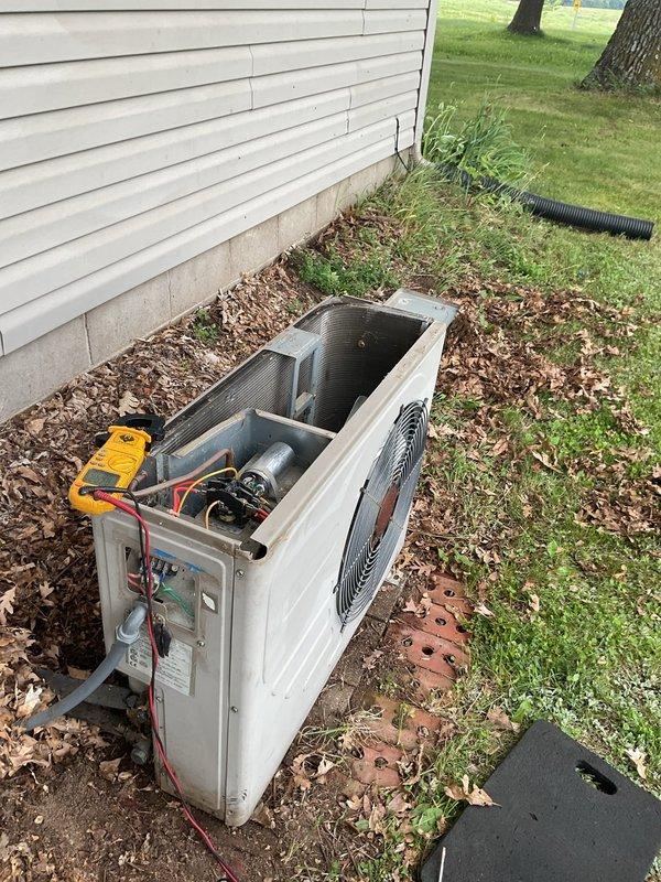 Responded to no cooling complaint on 20-year-old AC system where condenser fan was running but compressor would not engage. Found contactor with excessive residue buildup preventing proper closure and electrical contact. Performed temporary cleaning of contactor contacts to restore immediate functionality. Advised that contactor requires replacement due to age and condition, noting unit utilizes 120V coil contactor which may require special ordering. System restored to operational status temporarily, but recommended replacement of failed component for reliable long-term operation.