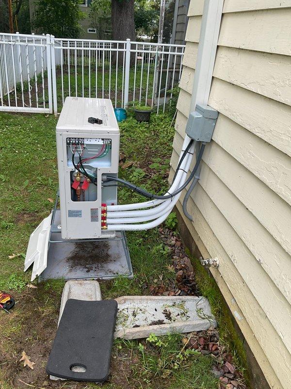 Responded to service call for newly installed Mitsubishi mini-split system with no heating or cooling operation. Diagnosed wiring issue at indoor air handler terminal connections and corrected wire assignments between heads A and B at the control panel. Verified proper operation of both zones, confirmed condensate drainage from drain lines, and identified improper condensate discharge onto window sill requiring installer callback to install PVC drainage piping away from building structure to prevent wood damage.