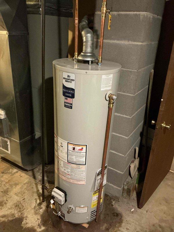 Responded to emergency water heater failure with severe leaking from tank bottom and ruptured condition causing water discharge onto basement floor. Removed and replaced failed 40-gallon natural gas Bradford White water heater with new unit, including all necessary connections to existing copper supply lines and gas piping. Completed installation with proper venting, pressure relief valve assembly, drain valve configuration, and tested all connections for leaks and proper operation.