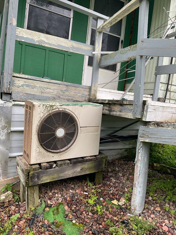Responded to no-cooling complaint on approximately 35-year-old system where outdoor fan operates but compressor fails to start. Upon arrival, delayed initial inspection due to severe lightning and heavy rain for safety. After weather cleared, began diagnostic evaluation and discovered unit lacks proper disconnect switch at condenser, with unclear power shutoff location at pole-mounted electrical equipment. Observed evaporator coil freeze-up and oil residue on suction line indicating potential refrigerant leak. Unable to complete full diagnostic or repairs due to unsafe electrical configuration requiring licensed electrician to establish proper disconnect and verify power source before proceeding with compressor circuit testing. Recommended electrical service prior to HVAC repairs to address failed compressor start (suspected capacitor failure) and low refrigerant charge.