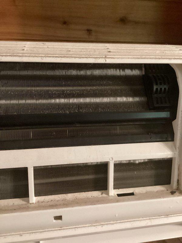 # HVAC Service Completed

Responded to service call for wall-mounted mini-split system not cooling adequately. Upon arrival, performed visual inspection of both indoor evaporator unit and outdoor condensing unit. Removed front cover of indoor unit to access evaporator coil and internal components. Observed accumulated dust and debris on interior surfaces indicating lack of recent maintenance.

Proceeded to outdoor unit location to assess condenser operation and refrigerant system. Noted aged appearance of equipment with visible weathering and surface discoloration. Connected manifold gauges to service ports and performed refrigerant pressure analysis. Testing confirmed system was operating with low refrigerant charge, resulting in reduced cooling capacity.

Identified refrigerant leak as root cause of low charge condition. Inspected refrigerant line connections, service ports, and coil assemblies for signs of leakage. Due to age of equipment and existing warranty complications with ano