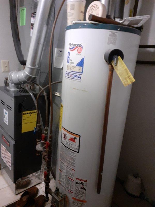 Conducted on-site assessment for water heater replacement options. Customer requested quote for heat pump water heater installation with preference for 40-gallon gas unit. Documented existing Richmond Integra 6-year warranty gas water heater installation, photographed current mechanical room configuration including furnace, water softener system, plumbing connections, and copper piping with shutoff valves for accurate replacement planning and specifications.