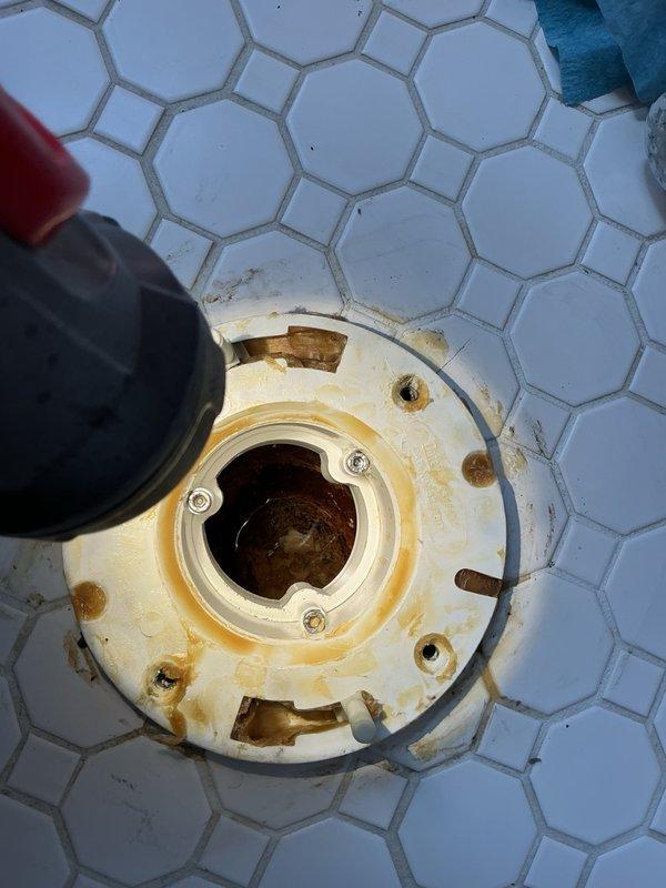 Responded to upstairs toilet leaking into ceiling below. Removed toilet to diagnose issue and found cast-iron repair flange loose and rocking excessively. Secured and tightened repair flange to cast-iron drain to ensure stable connection. Reset toilet with proper shimming to achieve level installation and prevent future movement. Performed multiple flush tests to verify watertight seal. Additionally replaced deteriorated fill valve to restore proper tank function.