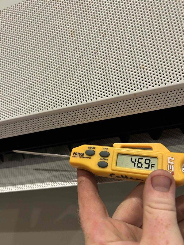 Responded to no cooling complaint on mini split system. Found unit low on refrigerant charge. Performed leak check at service ports with electronic detector showing no leaks at connection points, indicating refrigerant loss occurring elsewhere in system. Added refrigerant charge and UV dye to system for future leak detection. Verified proper cooling operation with supply air temperature reading of 46.9°F and confirmed system pressures and superheat readings within acceptable range at 15.9 PSIG with 126.9°F superheat on R-410A refrigerant. System restored to normal cooling operation.