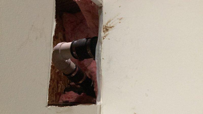 Responded to a water leak in the basement originating from the kitchen drain line above. Performed investigative access by cutting into the ceiling to locate the source. Identified a cracked ABS 90-degree elbow fitting on the kitchen sink drain line. Removed the damaged fitting and replaced it with a new 90-degree elbow using a Fernco flexible coupling to ensure a watertight seal. The leak has been successfully repaired and the drainage system restored to proper operation.