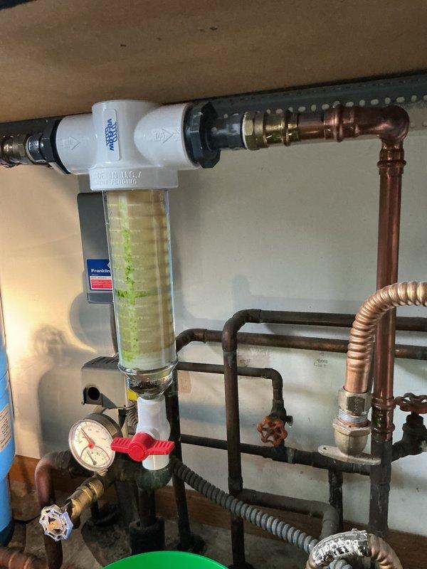 Responded to a pinhole leak in copper piping located in the utility room mechanical area. Upon inspection, identified a small leak in the copper line and observed widespread corrosion throughout the copper piping system and fittings, indicating advanced aging of the plumbing infrastructure. The existing system includes a water filtration unit with pressure regulation components, multiple copper supply lines, and various valve assemblies showing signs of oxidation and patina buildup.

Performed immediate repair of the active pinhole leak to stop water intrusion and restore system integrity. Documented the extensive corrosion present on copper pipes and fittings throughout the mechanical room for follow-up evaluation. Recommended comprehensive assessment for potential re-piping of remaining copper lines due to the deteriorated condition of the existing plumbing system to prevent future failures.