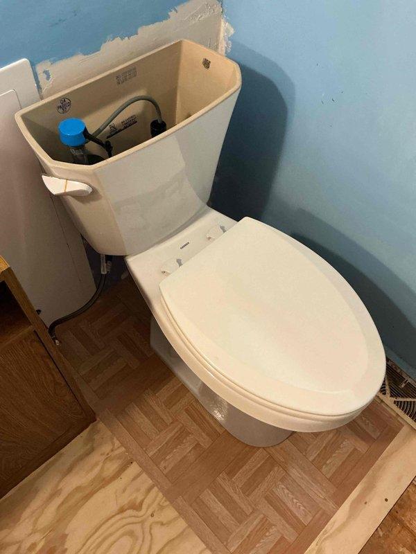 Completed installation of new ADA-compliant elongated toilet per estimate specifications. Replaced existing toilet flange to ensure proper seal and stability. All internal tank components, including fill valve and flush valve assembly, were installed and tested for proper operation. Work included removal of old fixture, preparation of mounting surface, and secure installation of new two-piece toilet unit with all necessary hardware and wax ring seal. System was tested and verified to be functioning correctly with no leaks detected at supply line or base connections.