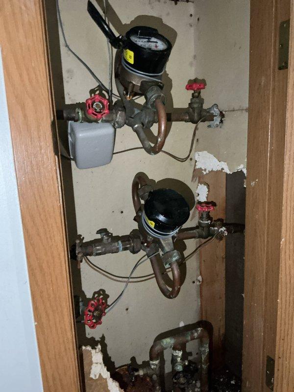 Responded to a multi-unit property for persistent water leak investigation following a previous repair attempt. Upon arrival, discovered water on the floor of Unit A, traced the source to a pinhole leak in the piping system after the water meter serving Unit B. Diagnosed that the initial repair had not resolved the underlying issue, as moisture continued to accumulate. Replaced the defective shut-off valve and 90-degree elbow fitting on the affected line to eliminate the leak source. The work was performed on aging galvanized piping with existing oxidation and corrosion present throughout the system. Verified proper installation of new components and confirmed no active leaking upon completion of valve and fitting replacement.
