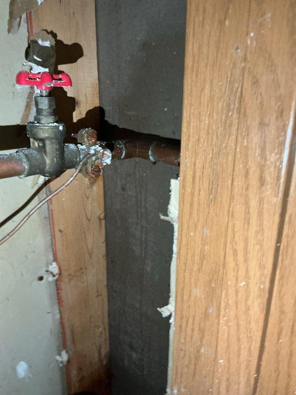 Responded to a multi-unit property for persistent water leak investigation following a previous repair attempt. Upon arrival, discovered water on the floor of Unit A, traced the source to a pinhole leak in the piping system after the water meter serving Unit B. Diagnosed that the initial repair had not resolved the underlying issue, as moisture continued to accumulate. Replaced the defective shut-off valve and 90-degree elbow fitting on the affected line to eliminate the leak source. The work was performed on aging galvanized piping with existing oxidation and corrosion present throughout the system. Verified proper installation of new components and confirmed no active leaking upon completion of valve and fitting replacement.