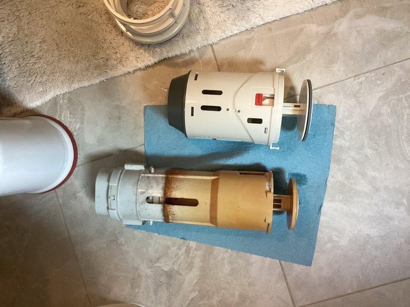 Responded to service call for toilet flush valve replacement. Upon arrival, assessed existing flush valve system and determined standard diameter valve and gaskets were required. Attempted installation of replacement flush valve mechanism; however, during rebuild process discovered the parts provided were incompatible with the existing toilet fixture. Documented the incorrect components with comparison photos showing the old deteriorated flush valve alongside the new unit to verify dimensional and mounting discrepancies. Additional parts with correct specifications will be required to complete the flush valve replacement and restore proper toilet function.