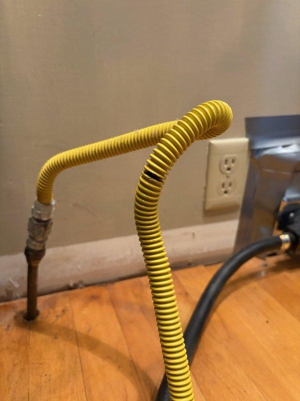 Responded to a gas line leak at the stove connection. Upon inspection, identified a pinhole leak in the flexible gas connector whip. Removed the damaged corrugated stainless steel tubing (CSST) connector and installed a new flexible gas line with proper fittings. Installed a shut-off valve for safety compliance and code requirements. Pressure tested all connections to verify leak-free operation and restored gas service to the appliance.