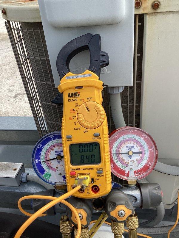 Completed scheduled AC maintenance and tune-up on rooftop R-22 system. Inspected filter which had been recently changed and found in acceptable condition. Performed diagnostic testing using manifold gauges and amp meter, revealing slightly low refrigerant pressures indicating possible undercharge. Observed multiple supply vents intentionally blocked with styrofoam sheets, which may be contributing to abnormal pressure readings and affecting system performance. Unit currently operating with 16-degree temperature split. Inspected electrical components including capacitor and contactor, both found in functional condition. System operational at conclusion of service visit, though low refrigerant charge may require attention in future.