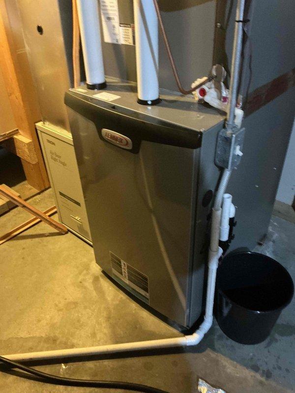 Responded to service call for water leaking from furnace during AC operation. Diagnosed plugged condensate drain line elbow on evaporator coil caused by debris accumulation. Disassembled all condensate drain fittings, cleared debris blockage, reassembled system, and performed flow test with water to verify proper drainage function. System restored to normal operation.