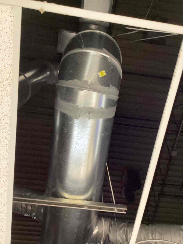 Responded to service call for excessive condensation issues in break room area where moisture was dripping from uninsulated HVAC ductwork during air conditioning operation. Inspected 15-inch round metal duct system and documented current conditions with photographs showing galvanized steel ductwork without insulation, resulting in condensate formation on exterior surfaces. Provided assessment and recommendations for insulating the affected ductwork to eliminate condensation problems, with project engineer scheduled for follow-up consultation.