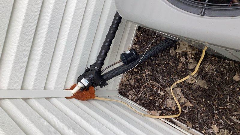 Installed electrical disconnect box on exterior wall adjacent to air conditioning condenser unit that was previously operating without proper safety disconnect. Ran new electrical whip from disconnect to condenser and replaced low voltage communication wire from indoor furnace to outdoor unit. System tested and verified to be operating normally with all electrical connections properly secured and compliant with safety requirements.