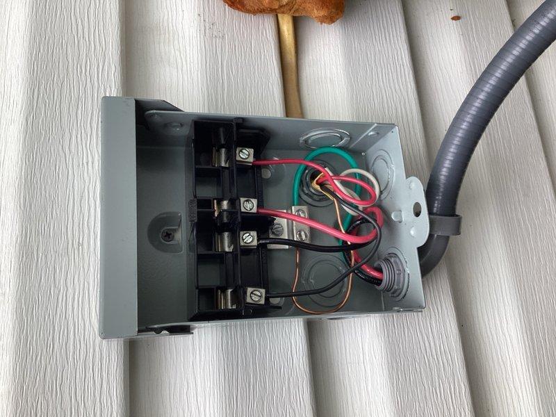 Installed electrical disconnect box on exterior wall adjacent to air conditioning condenser unit that was previously operating without proper safety disconnect. Ran new electrical whip from disconnect to condenser and replaced low voltage communication wire from indoor furnace to outdoor unit. System tested and verified to be operating normally with all electrical connections properly secured and compliant with safety requirements.