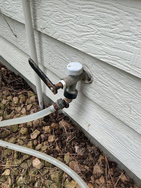 Responded to a continuously running front exterior hose bib that was leaking despite the homeowner's previous attempt to replace a bushing. Upon diagnostic inspection, removed the valve stem and identified a severely damaged rear seal as the source of the leak. Utilizing a seal kit provided by the customer, installed a new valve stem assembly and complete seal kit to restore proper function. Tested the hose bib for approximately 10 minutes following installation to verify complete leak cessation and proper operation. The spigot showed visible exterior corrosion and weathering consistent with extended outdoor exposure, but the internal repair successfully resolved the continuous water flow issue.