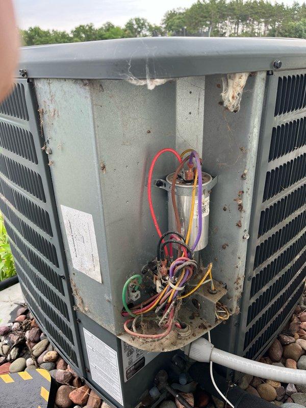 Responded to no cooling complaint on 13-year-old central air conditioning system. Upon arrival, found outdoor unit condenser fan motor operating but compressor not running. Diagnosed failed dual run capacitor with readings of 0 microfarads on compressor (HERM) terminal and approximately 2 microfarads on fan terminal, significantly below rated 40/5 microfarad specification.

Replaced defective capacitor with new dual run capacitor. Removed rodent intrusion (mice) from electrical cabinet and sealed wire entry penetrations with silicone to prevent future pest access. Cycled system through complete cooling operation and verified proper compressor engagement, condenser fan operation, and airflow. Measured 15-20 degree temperature split across evaporator coil, confirming system restored to normal cooling capacity.